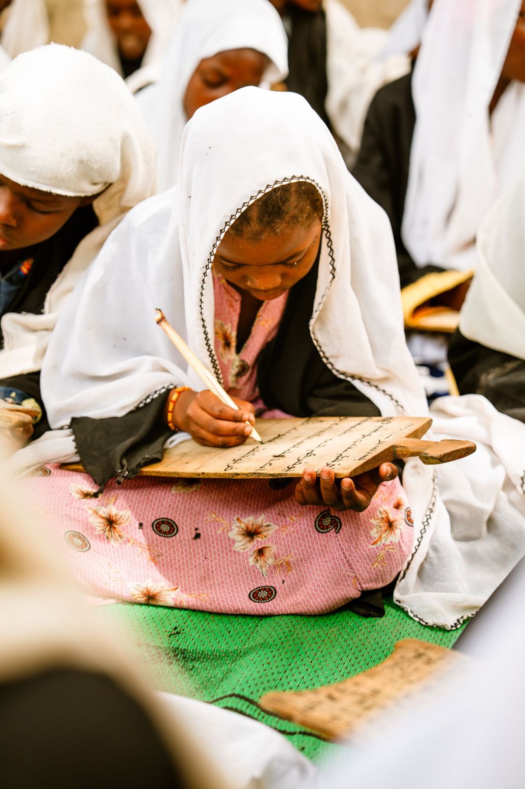 A girl writing on a wooden tablet